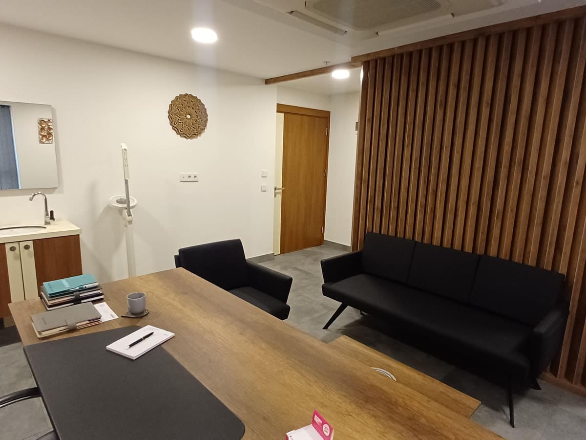 Görüşme odası: çalışma masası ve ahşap panelli oturma alanı